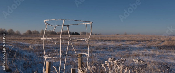 Obraz FROSTY WINTER - Snow on the fields and morning rime on the wire protector of a young tree and on the weeds