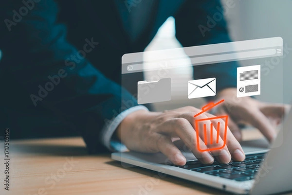 Obraz Businessman using laptop with hologram trash bin icon to delete email files and documents Concept of digital data management secure file removal cyber security paperless workflow and technology