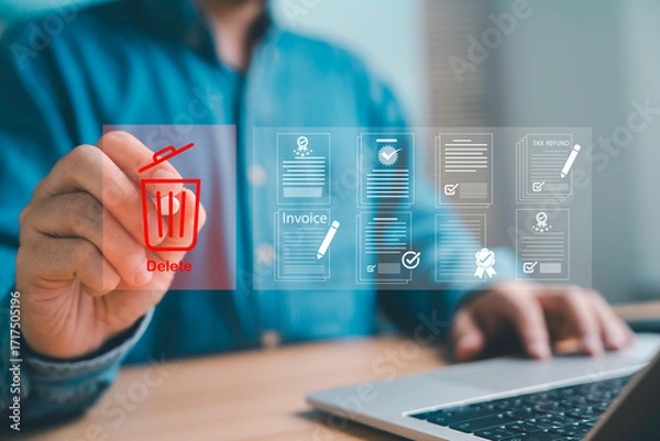 Obraz Businessman using digital interface to delete electronic documents invoices and tax forms on laptop Concept of data management paperless office and secure file storage
