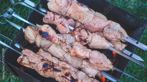 Obraz Shashlik on skewers is being cooked on charcoal in a barbecue close-up.