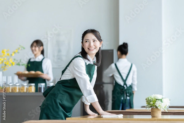 Fototapeta カフェで開店準備をする若い女性の店員