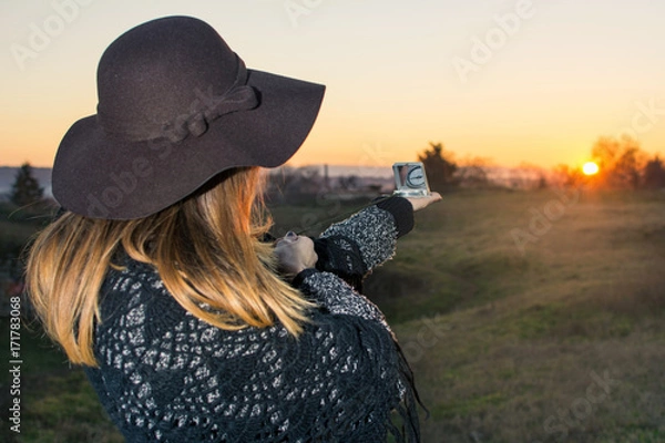 Obraz Girl with compass at sunset