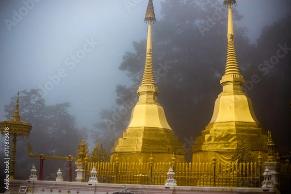 Fototapeta The background of the religious tourist attraction Wat Phra That Doi Tung in the mist in Chiang Rai Province, Thailand, where travelers often stop to make merit.
