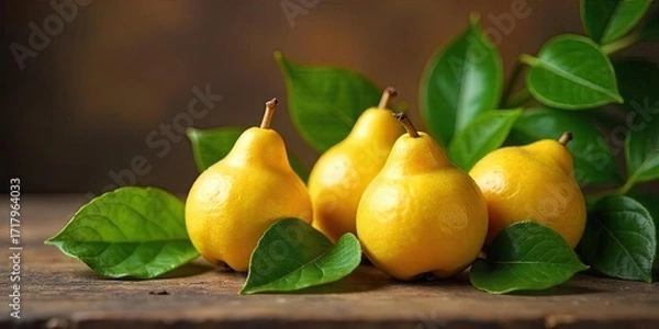 Fototapeta A cluster of ripe, golden-yellow pears nestled amongst vibrant green leaves on a rustic wooden surface