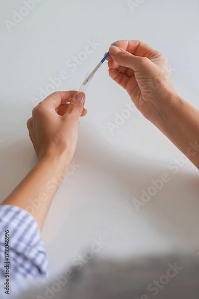 Obraz Hands using an at-home rapid antigen test for remote care: self-swab, easy sample, quick result. Ideal for telemedicine, COVID or strep screening, digital health, online doctor pharmacy