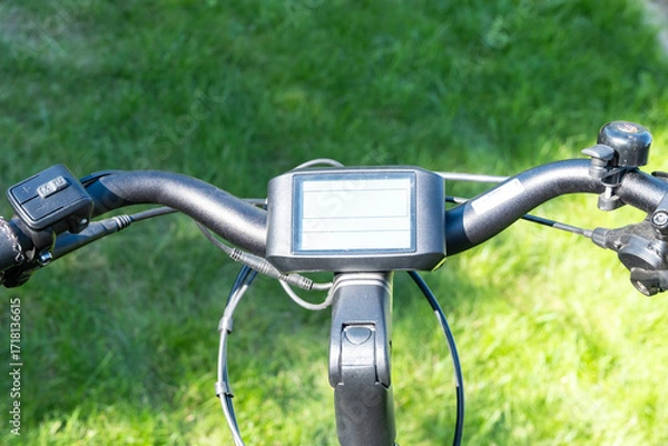 Fototapeta Close-up of electric bike computer on handlebar, detail of modern bicycle technology and digital display