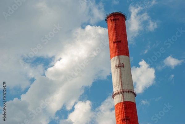 Obraz Red and White Factory Chimney Against Blue Sky with Clouds
