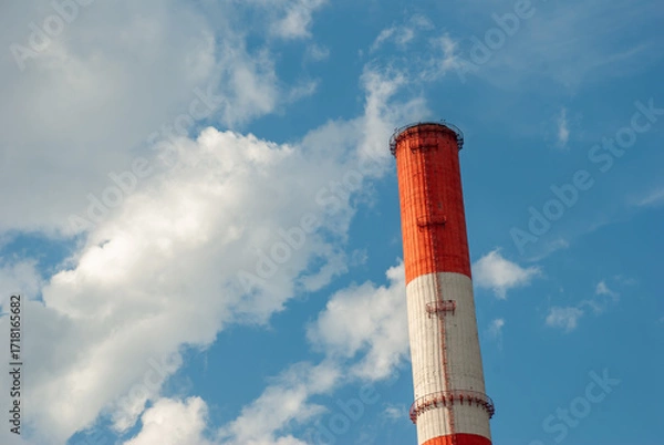 Obraz Red and White Factory Chimney Against Blue Sky with Clouds