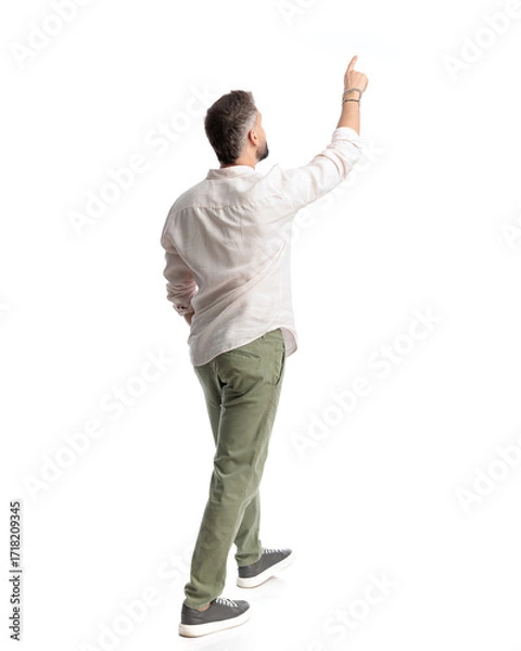 Obraz back view of young man pointing finger to the sky and walking