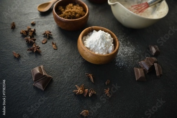 Fototapeta High angle view of flour with spice and chocolate bars