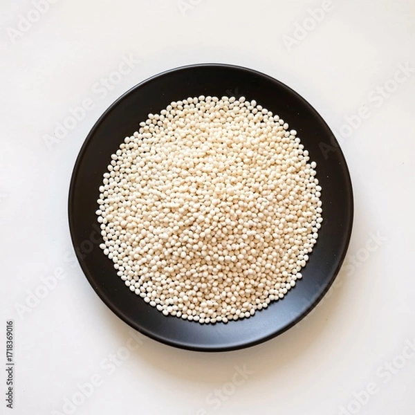 Obraz White Quinoa Grains Displayed on Round Black Plate Isolated Background