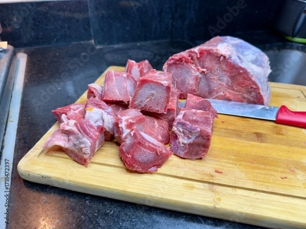 Fototapeta Carne em cubos cortas sobre a mesa com fundo desfocado e cebolas e panela con nivel de agua.