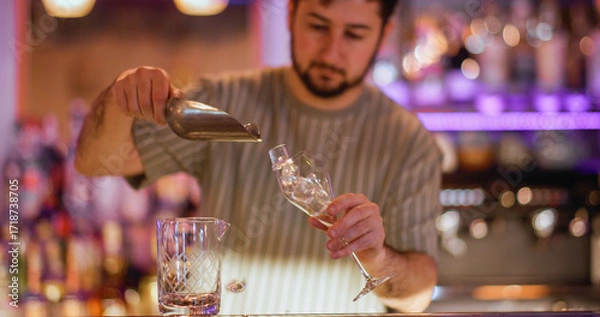 Fototapeta Preparing cold drink. Barkeeper workspace. Man pouring ice cubes with scoop in wineglass. Professional worker making refreshing beverage.