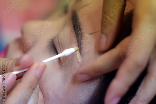 Fototapeta Using concealer to cover eyebrows.