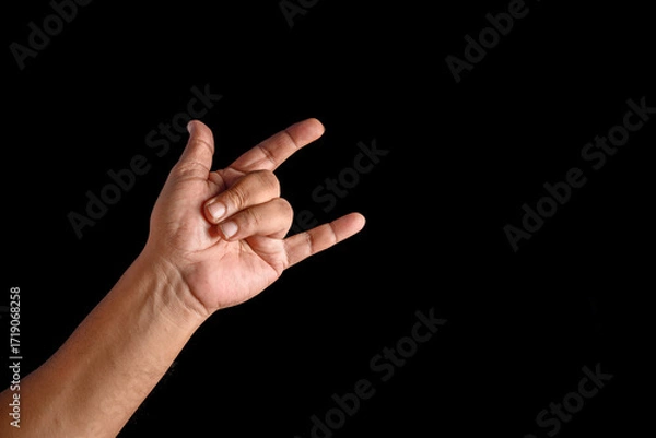 Fototapeta Hand Showing Rock Gesture on a Black Background for Conceptual Use