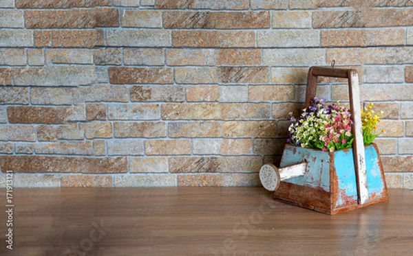 Fototapeta Wooden vase with watering shaped on wood table for decoration in gardening or home and put the colorful flowers in vase
