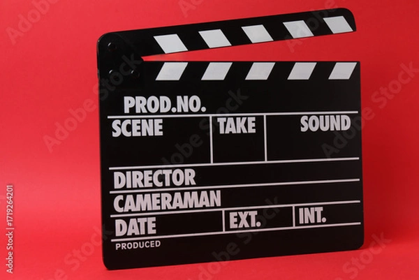 Fototapeta Cinema clapper and reel on a red background

