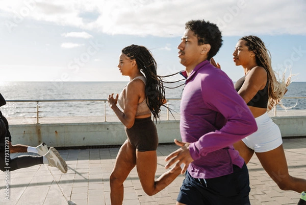 Fototapeta A group of three athletes running behind two athletes