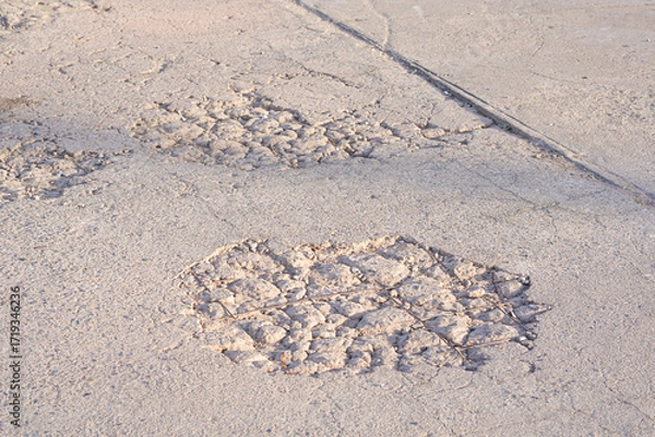 Fototapeta The old damaged street background with worn and broken texture on concrete road surface