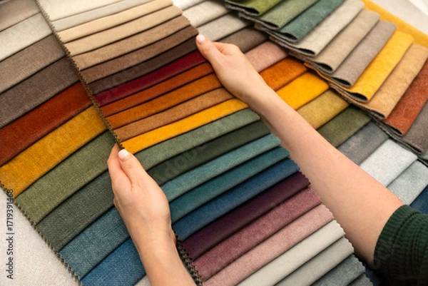 Fototapeta Hands holding fabric swatches for custom furniture and upholstery, textile samples for interior design, home decoration and creative material selection.