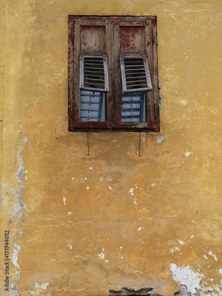 Fototapeta An Old Rustic Wooden Window On A Yellow Wall