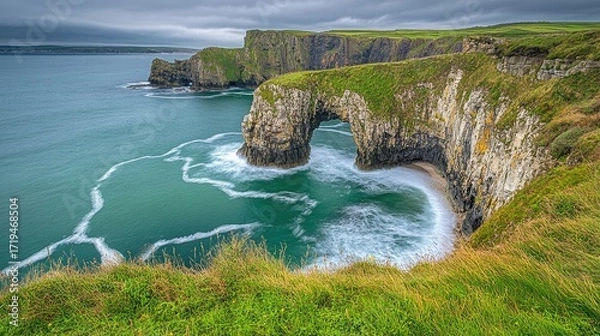 Fototapeta Rough waves pushing their way into a dark ocean cave at Carrick-a-Rede, Northern Ireland, creating a powerful scene.