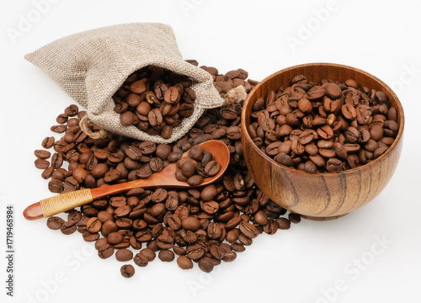 Fototapeta Roasted coffee beans in a jute bag with wooden cup and spoon isolated on white background. Coffee beans background texture.