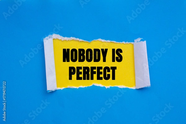Fototapeta Nobody is Perfect message written on ripped torn blue paper on yellow background. Conceptual Nobody is Perfect symbol. Copy space.