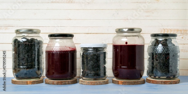 Fototapeta freshly picked blackberries and the jam made with them in glass jars on beautiful background