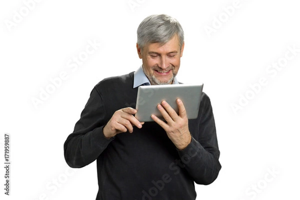 Fototapeta Mature man smile reading news on tablet. Happy senior man looking on pc tablet and smiling on white background.