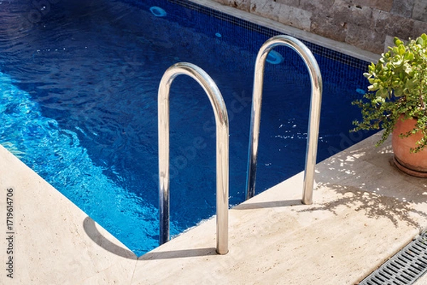 Fototapeta Grab bars inviting for a refreshing dip in a crystal-clear swimming pool