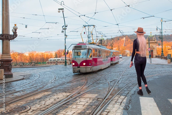 Fototapeta Red tram passing on  Bridge and famous Prague Castle on the background in Prague, Czech Republic.