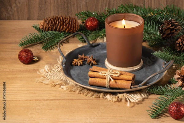 Fototapeta A Christmas arrangement with a candle, fir tree branches, and spices. Cinnamon, anise, candle, fir tree, Christmas decor