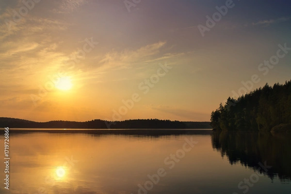 Fototapeta Sunset at the lake with reflection and forest, peaceful evening atmosphere