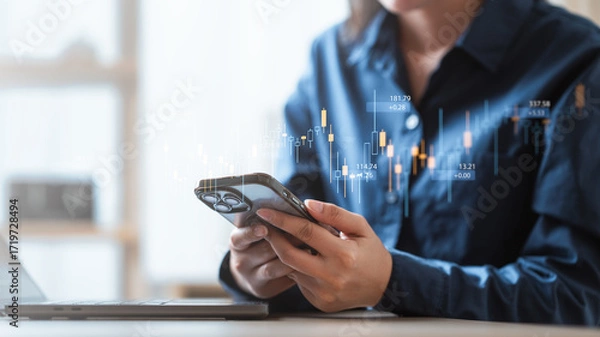 Fototapeta Person using smartphone with stock market chart overlay, symbolizing digital finance, stock trading, investment strategy, and financial market analysis in modern economy.
