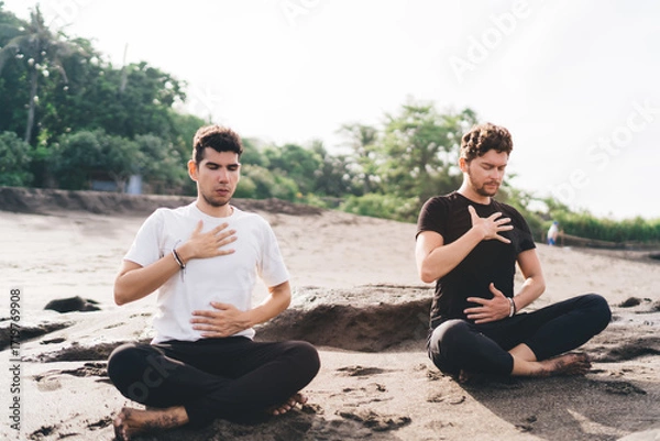 Fototapeta Two men seated in deep breath awareness, hands on chest and belly—anchoring presence as method for digital decompression and embodied cognitive recovery.