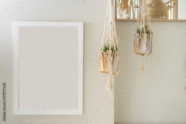 Obraz White picture frame mockup and home decor on table. Scandinavian living room interior design. Nordic style.