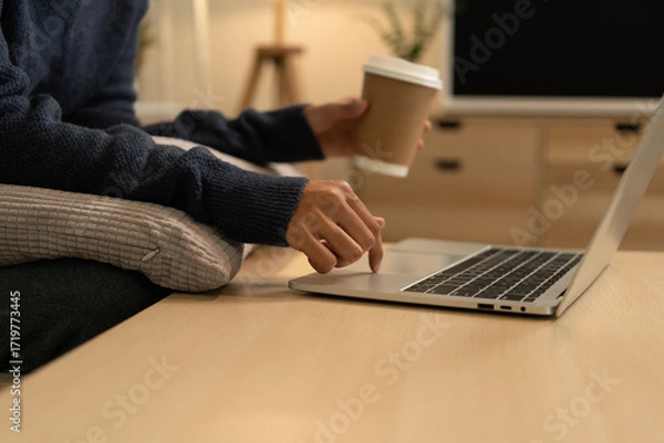 Fototapeta Young Asian woman enjoying a peaceful moment reading a book near window. Calm lifestyle, self-learning, and mindfulness at home.