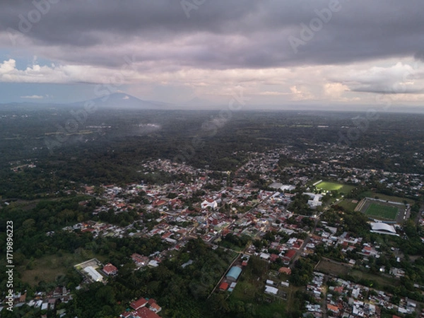 Fototapeta Scenic view of town surrounded by mountains and greenery