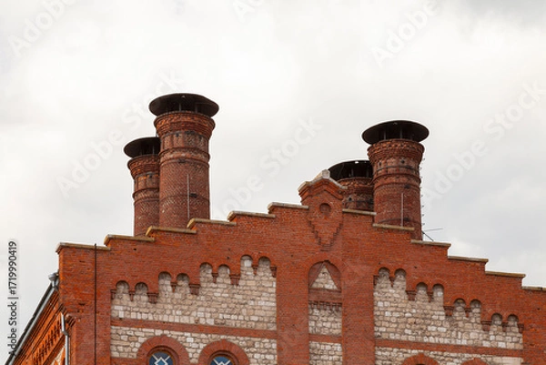 Fototapeta Brick chimneys of an old factory against the sky