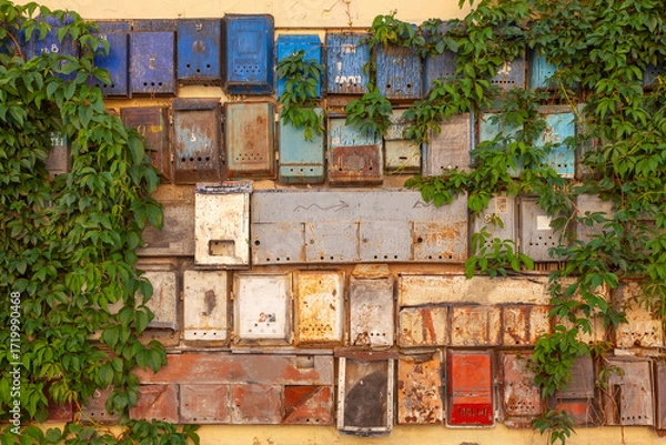 Fototapeta Various old mailboxes on the wall of a house. Some have the Russian inscription "Post Office" on them