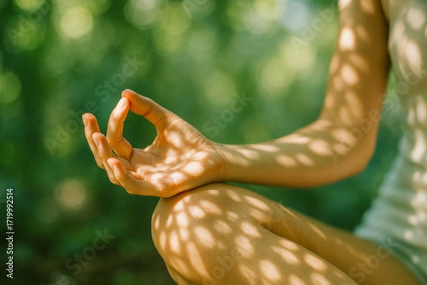 Fototapeta Meditation hand in Gyan mudra with dappled sunlight on skin, green bokeh background