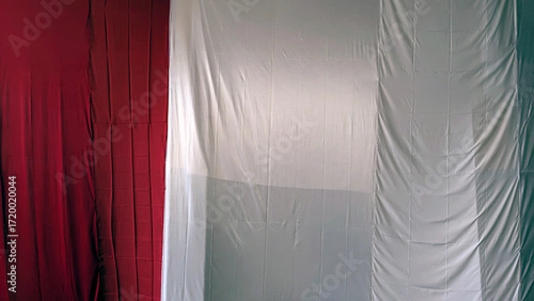 Obraz Draped fabric resembling an Italian or Indonesian flag, partially concealed, showing red, white, and green sections.