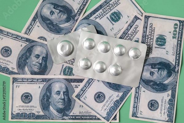 Fototapeta A blister pack of pills and a stack of dollars on a color background.