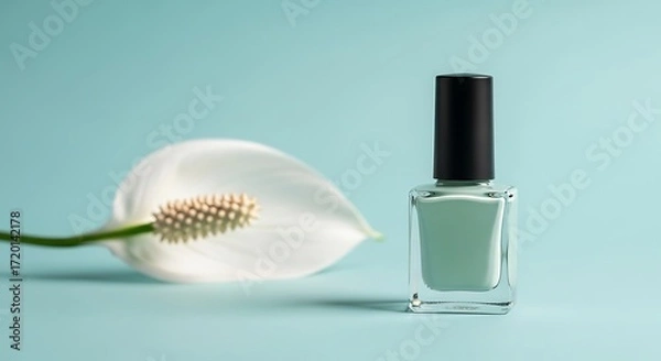 Fototapeta Elegant pale green nail polish bottle next to a white calla lily flower
