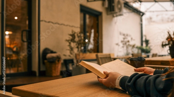 Fototapeta Reading a book at a cafe