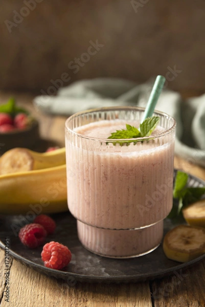 Fototapeta Refreshing banana raspberry smoothie with fresh mint for healthy living and summer enjoyment. Copy space.