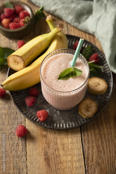 Fototapeta Refreshing banana raspberry smoothie with fresh mint for healthy living and summer enjoyment. Copy space.