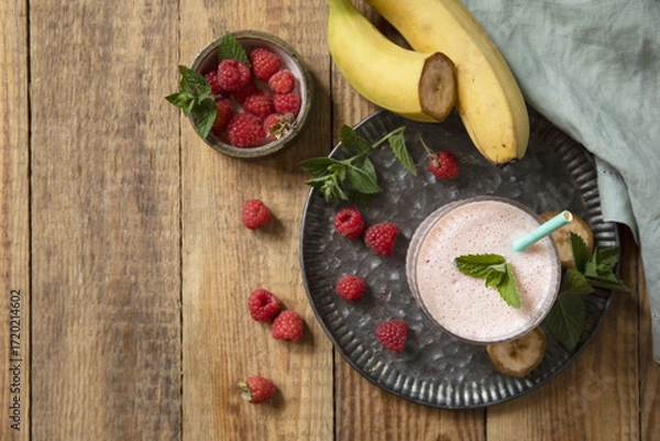 Fototapeta Refreshing banana raspberry smoothie with fresh mint for healthy living and summer enjoyment.