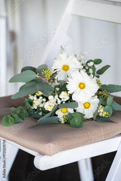 Fototapeta White floral bouquet with roses and daisies arranged in elegant vase for wedding table decoration, natural fresh flowers as romantic festive centerpiece for ceremony, celebration and reception event